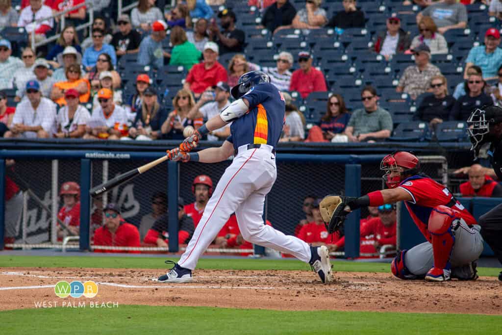 Baseball player swinging at a pitch during a game in West Palm Beach.