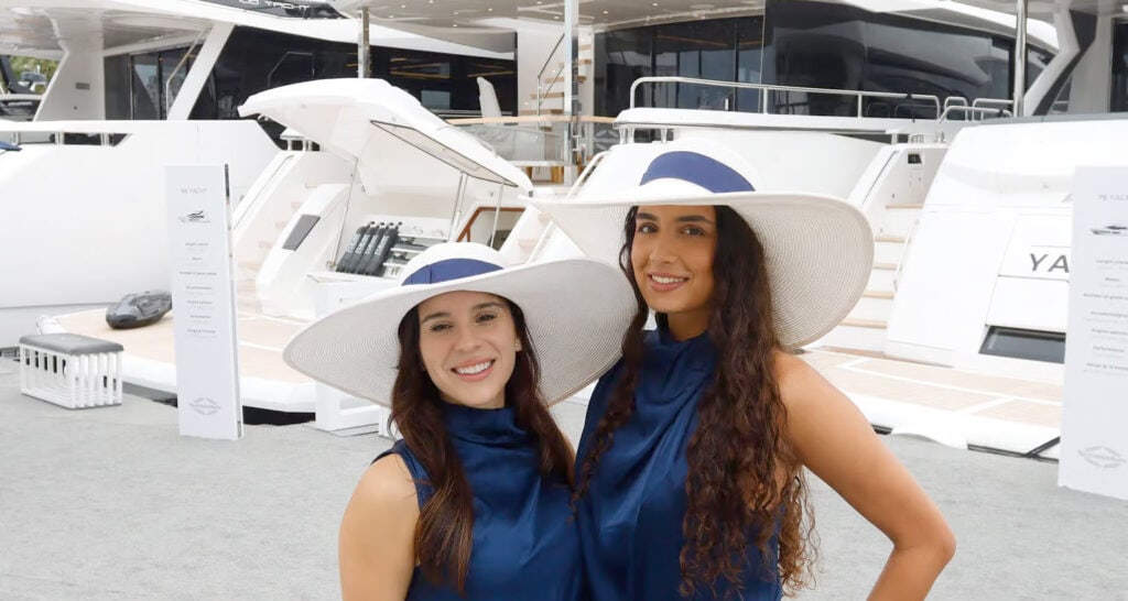 Beautiful women in stylish hats enjoying a sunny day at West Palm Beach marina.