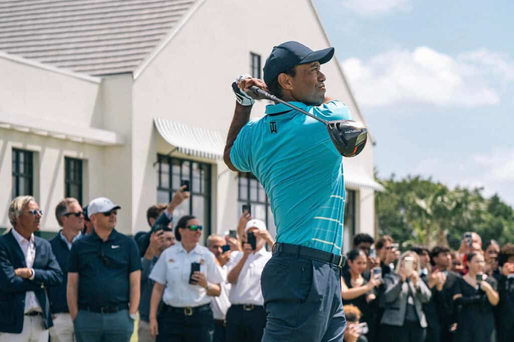 Golf player in blue shirt swinging club during a tournament in West Palm Beach.
