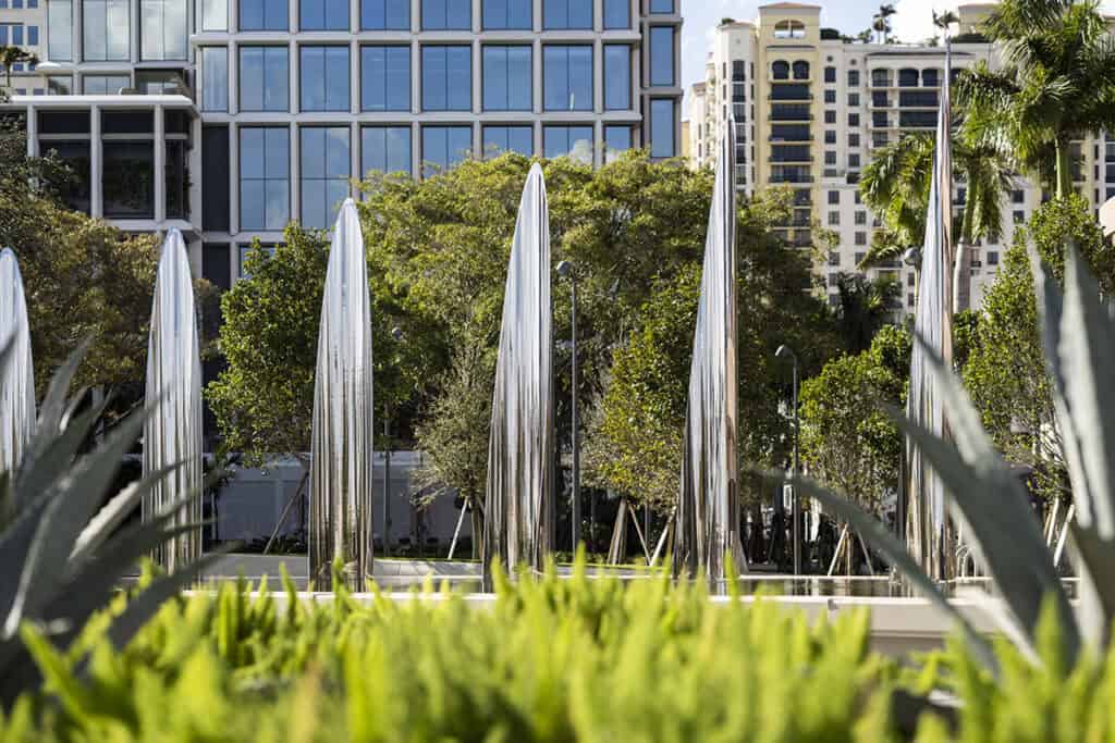 Famous fountain in West Palm Beach with modern buildings and lush greenery in the background.