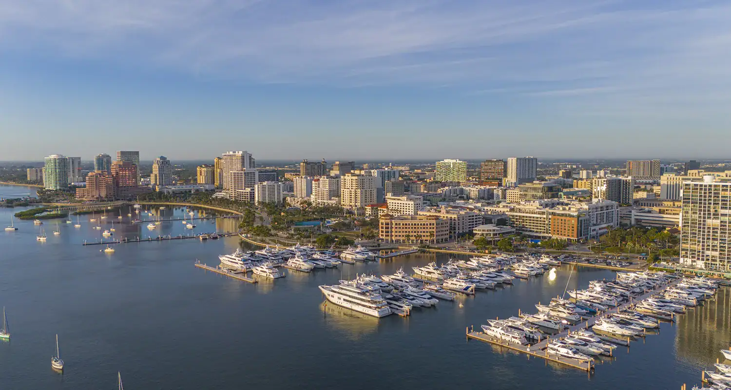 Aerial view of a city skyline with a marina and boats on the water.